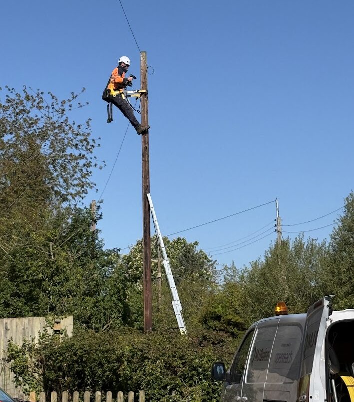 Telecoms engineer working on a telegraph pole