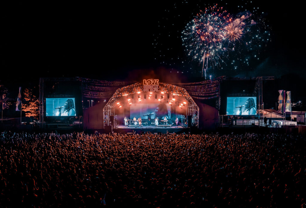 Photograph of the main stage at Love Supreme Festival at the closing of the headline act, with fireworks in the background.